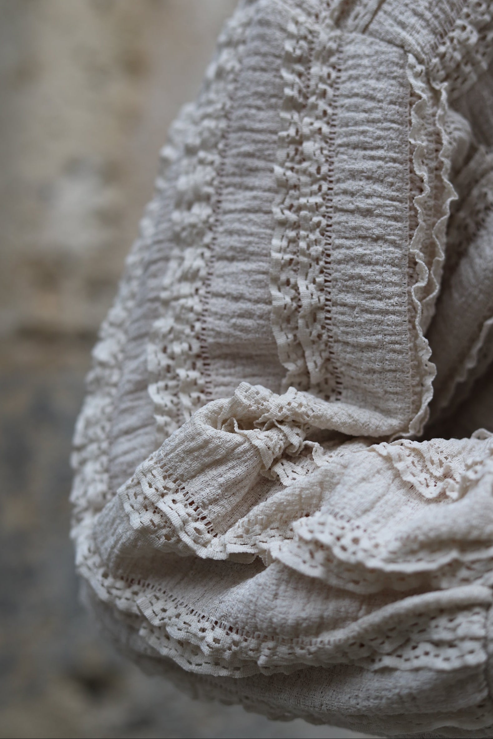 Femme portant un chemisier beige effet dentelle, coupe ample et texturée